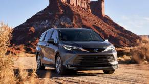 A gray 2022 Toyota Sianna Platinum on a desert road in front of a high cliff in the background.