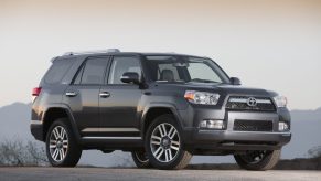 A dark grey 2013 Toyota 4Runner parked outside at dusk in right front angle view