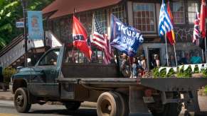 A heavy-duty Ram Cummins flat-bed truck with Trump and American flags on parade.