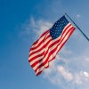 The American flag on a long pole, blue sky visible in the background.