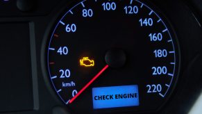 A close view of a car's instrument cluster with check engine lights on
