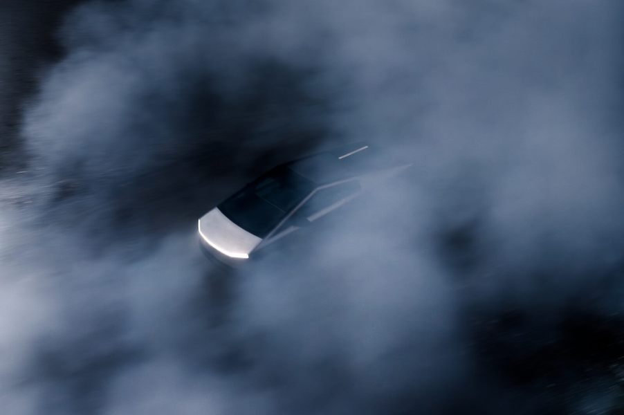 A Tesla Cybertruck speeds through the dust.