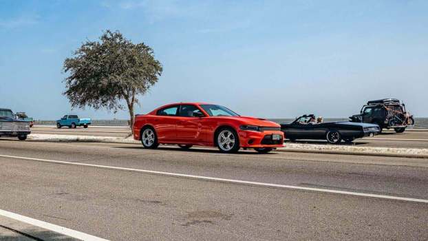 A red Dodge Charger goes driving by.