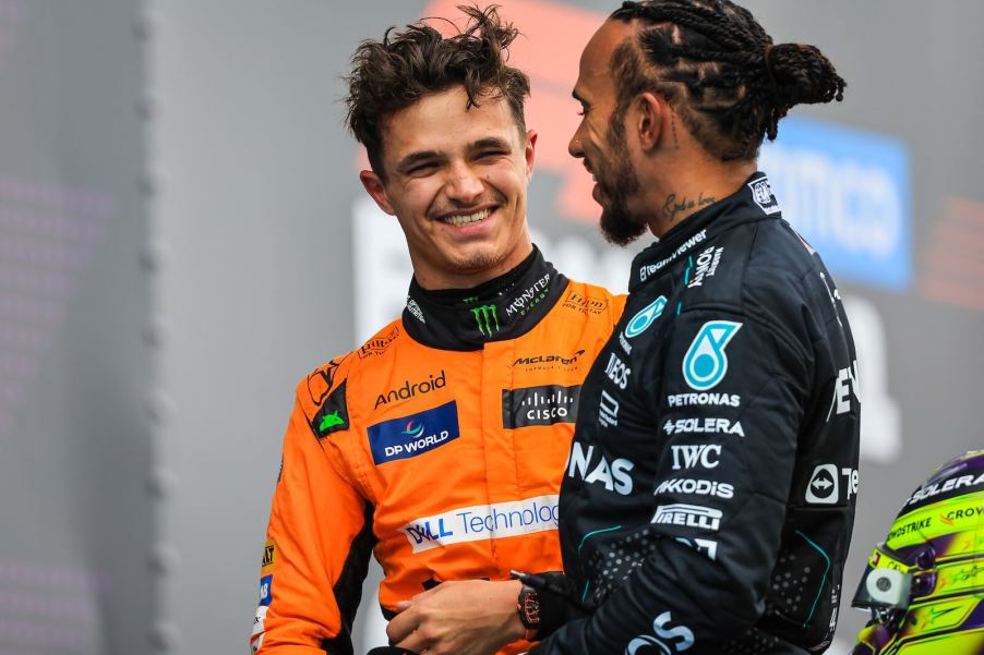Formula 1 (F1) drivers Lando Norris and Lewis Hamilton laugh together.