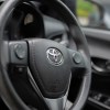 Toyota logo on the steering wheel of a used RAV4 crossover hybrid SUV.