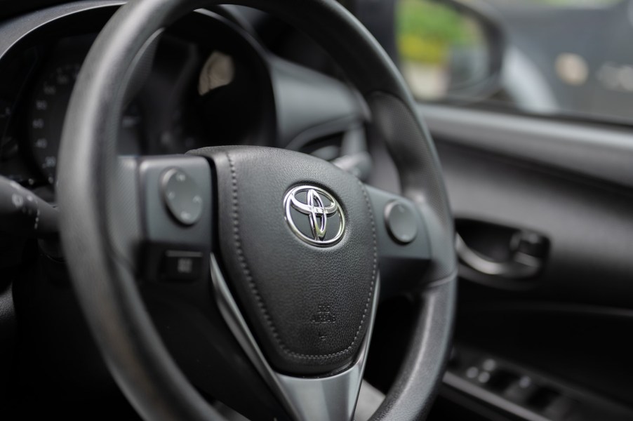 Toyota logo on the steering wheel of a used RAV4 crossover hybrid SUV.
