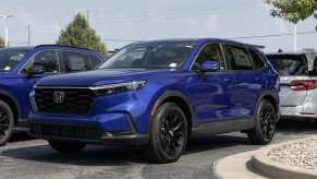 A blue Honda CR-V parked in a parking lot in left front angle view